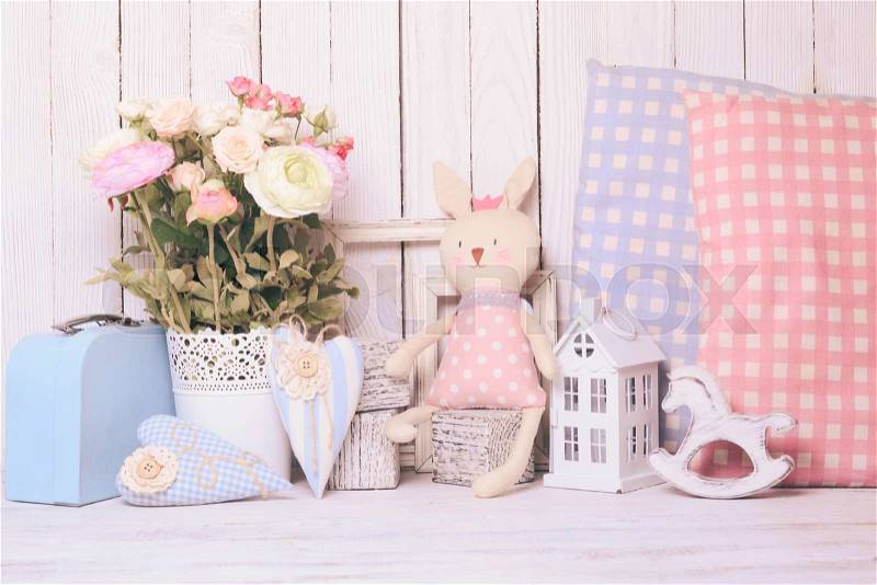Small toy house, pony, toy bunny, pillows in the children\'s room on wooden background, stock photo