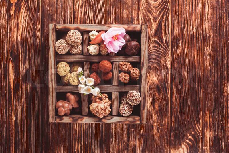 Assorted Chocolate candies in wooden box sells. Luxury handmade sweets, stock photo