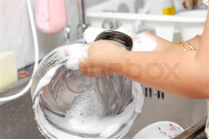 Woman hand wash pot in kitchen sink, stock photo