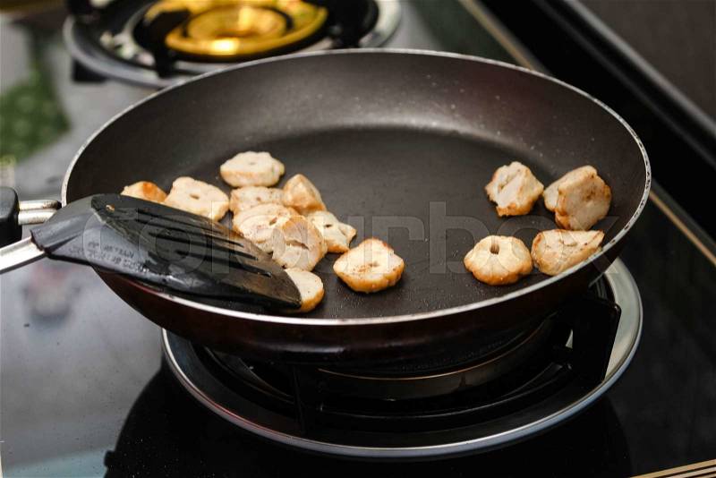 Fry pork in on frying pan stove, stock photo