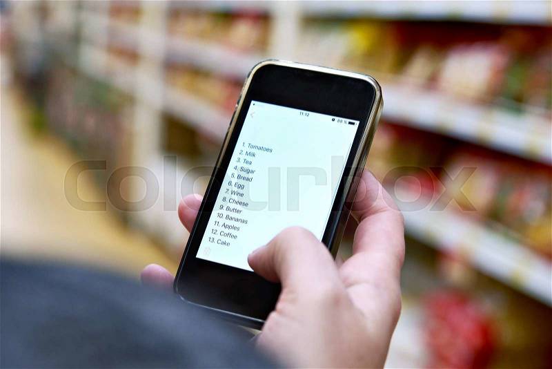 Shopping list on smartphone screen in the hand of women customers, stock photo