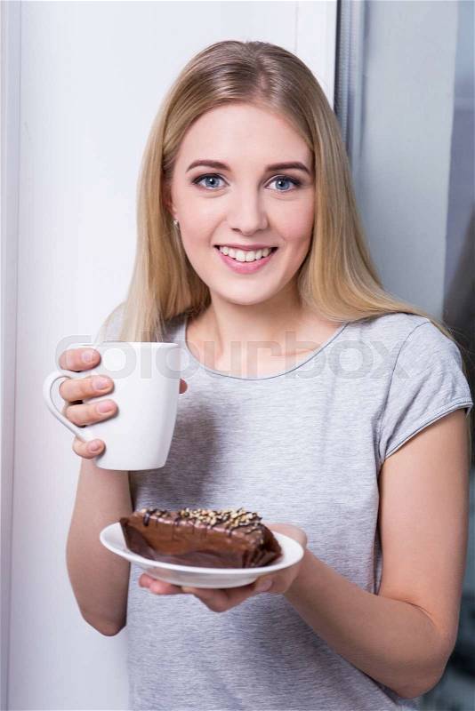 Happy woman with chocolate cake and cup of coffee or tea, stock photo