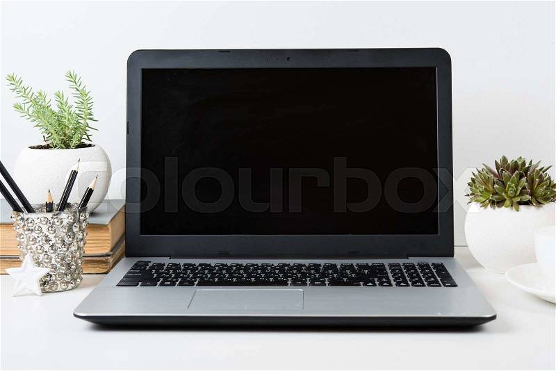 Realistic modern work space with laptop mockup on a table on white background, stock photo