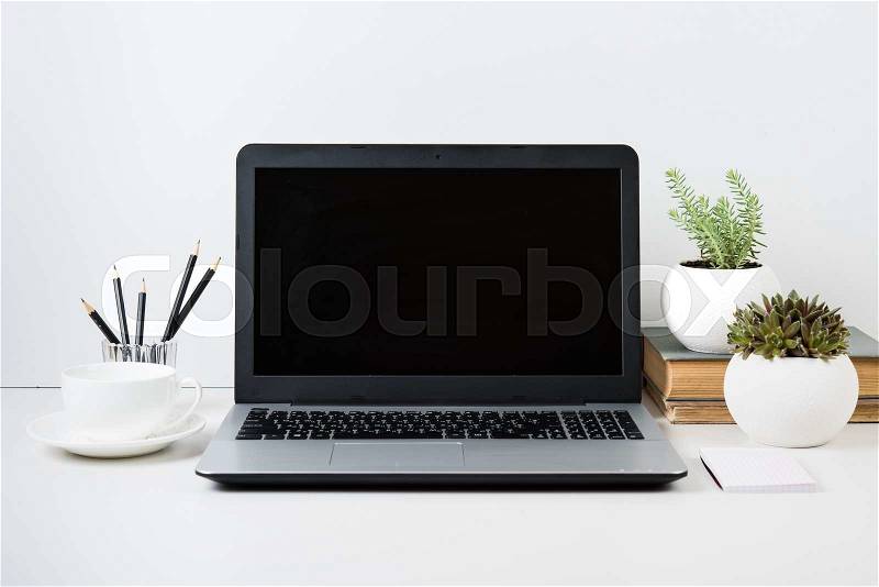 Realistic modern work space with laptop mockup on a table on white background, stock photo