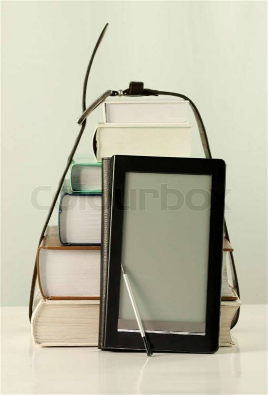 Stack of books and electronic book reader on the white background, stock photo