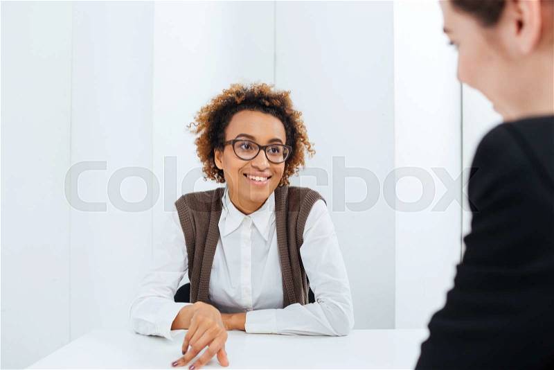 Cheerful african american businesswoman interviewing candidate for new position, stock photo