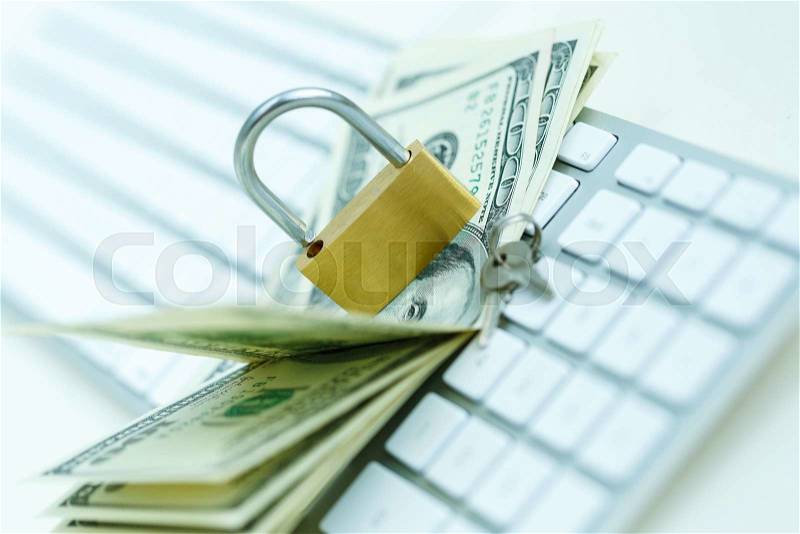 Security lock on dollar bills with white computer keyboard - breach of security online payments concept, stock photo