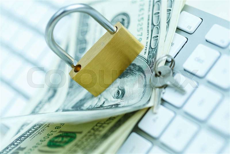 Security lock on dollar bills with white computer keyboard - breach of security online payments concept, stock photo