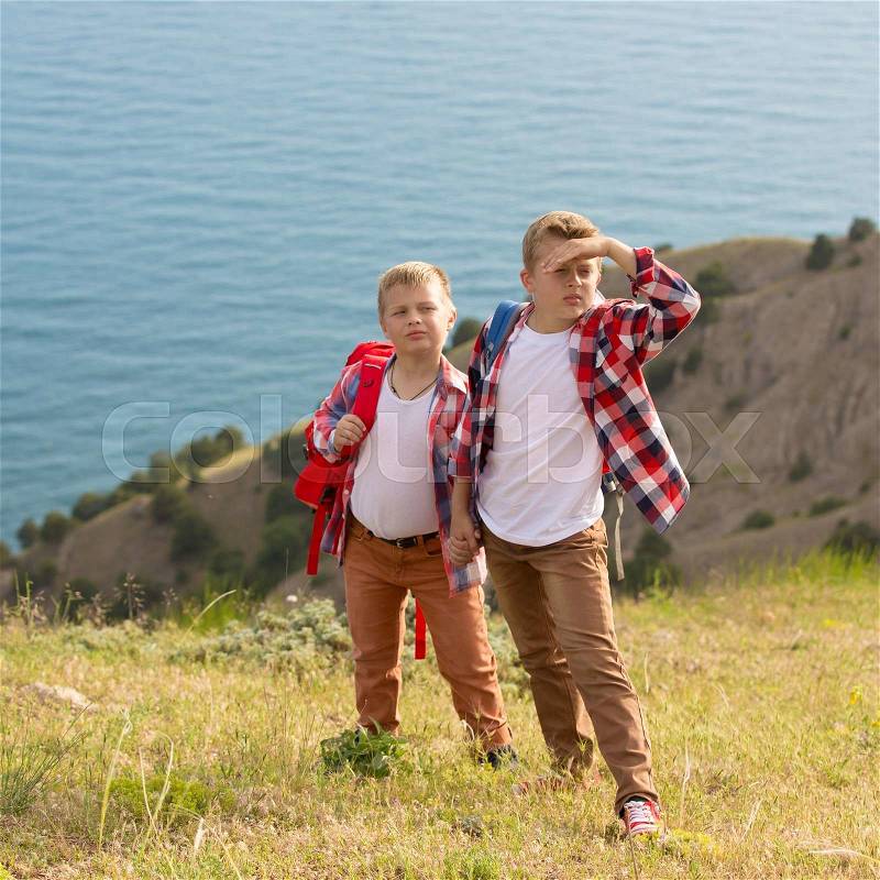 Two brothers walking in mountains near the sea, stock photo