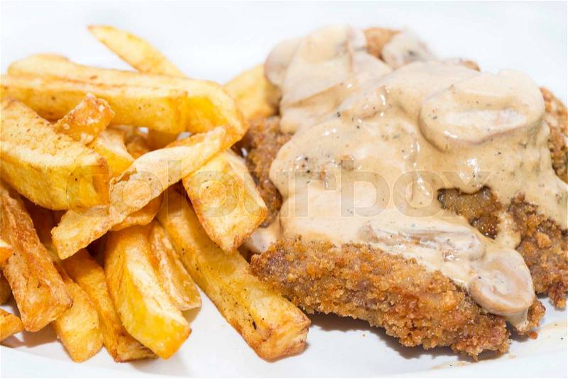 Schnitzel with mushroom sauce and french fries on a white background in the restaurant, stock photo