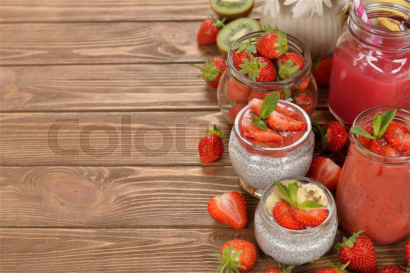 Diet desserts and drinks with chia seeds and strawberries on brown background, stock photo