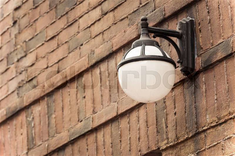 Old street lamp against a brick wall with vintage color, stock photo