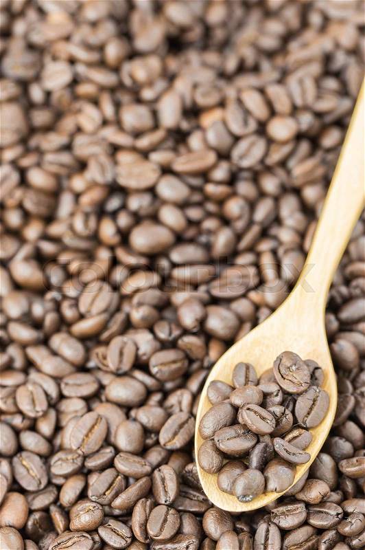 Coffee beans in spoon on roasted coffee seed background\\ , stock photo