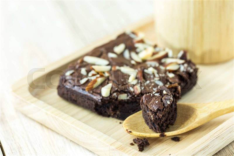 Brownie on wood plate with wooden mug on wood plank wall, stock photo