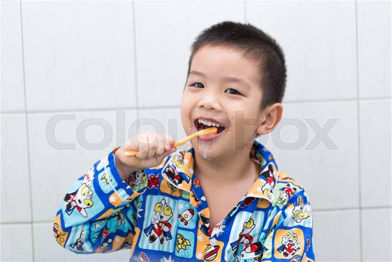 Little handsome Asian boy brushing Teeth in bath with smiling face, stock photo