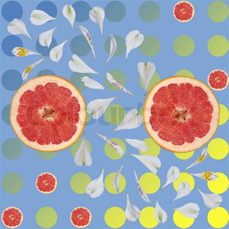 Grapefruit Against the background of circles and white flower petals on blue and yellow background, stock photo