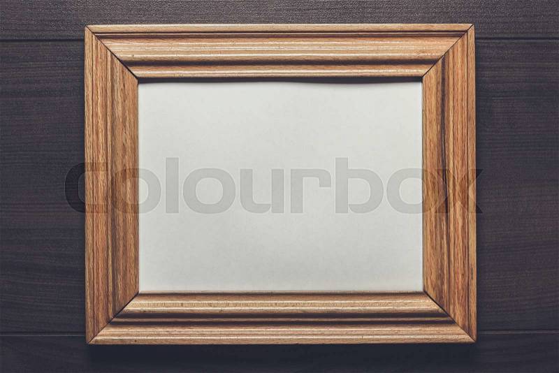 Old empty frame on wooden wall, stock photo