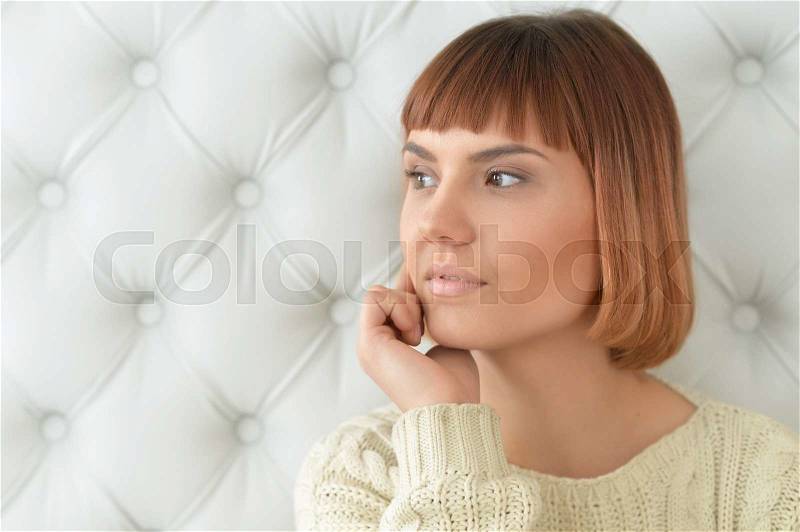 Sensual redhead woman with hand on chin looking away, stock photo