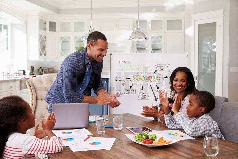 Family clapping at a domestic meeting in their kitchen, stock photo
