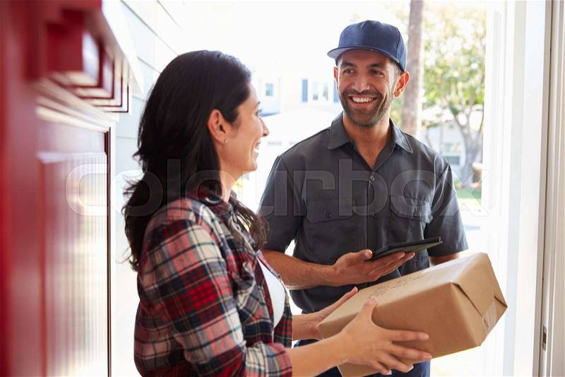 Woman Receiving Package From Courier At Home, stock photo