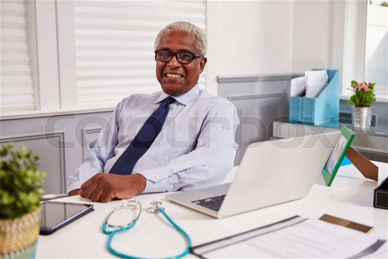 Senior black male doctor in an office looking to camera, stock photo