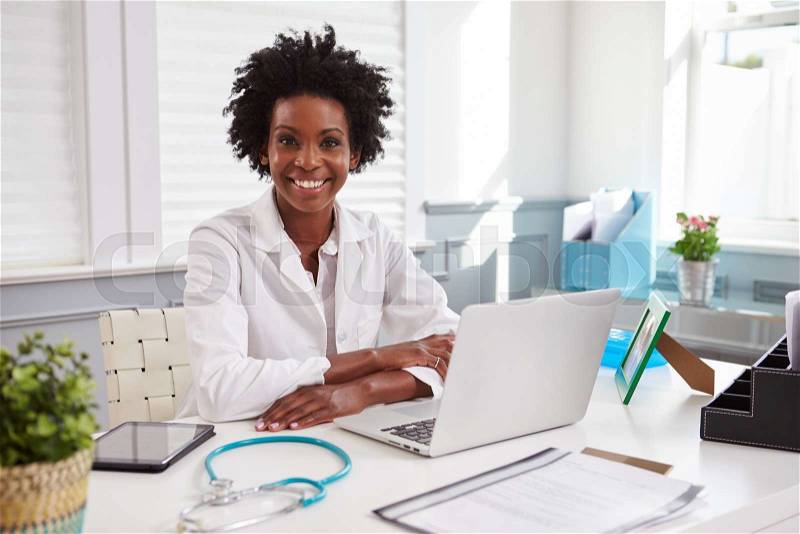 Female doctor in white coat looking to camera in an office, stock photo