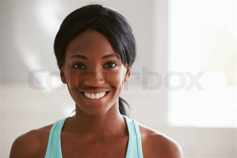 Head and shoulders portrait of smiling young black woman, stock photo