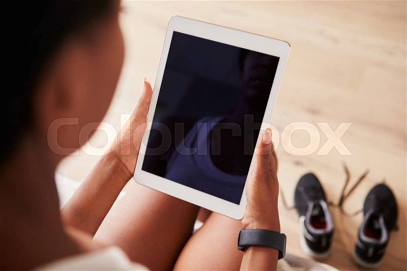 Young black woman using tablet computer, over-shoulder view, stock photo