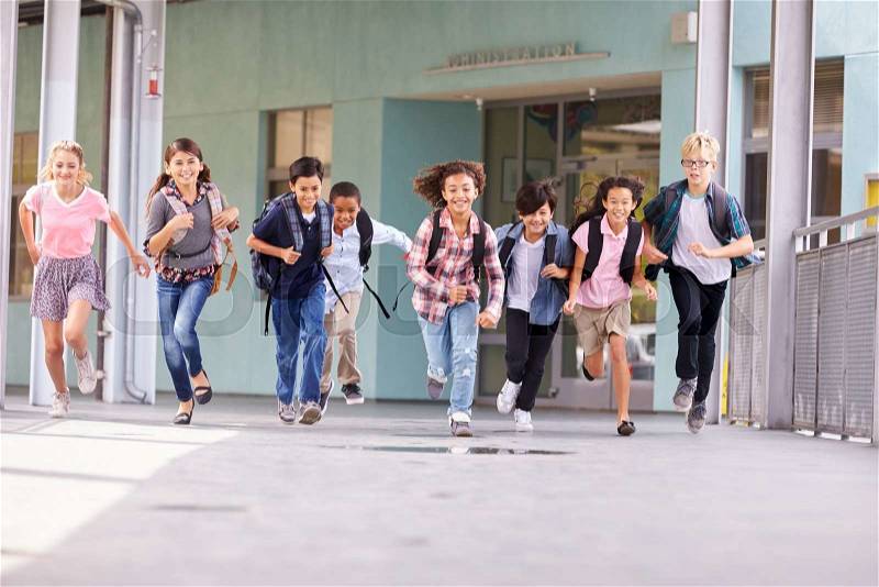 Group of elementary school kids running in a school corridor, stock photo
