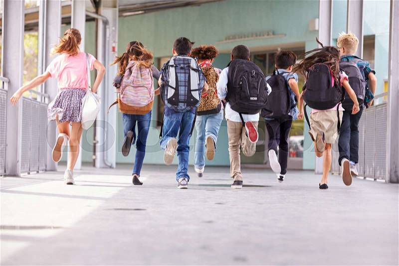 Group of elementary school kids running at school, back view, stock photo