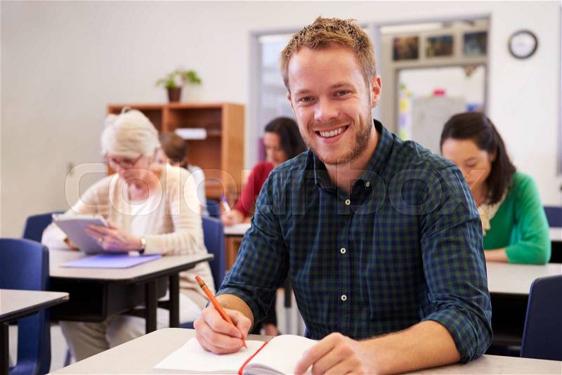 Young man at an adult education class looking to camera, stock photo