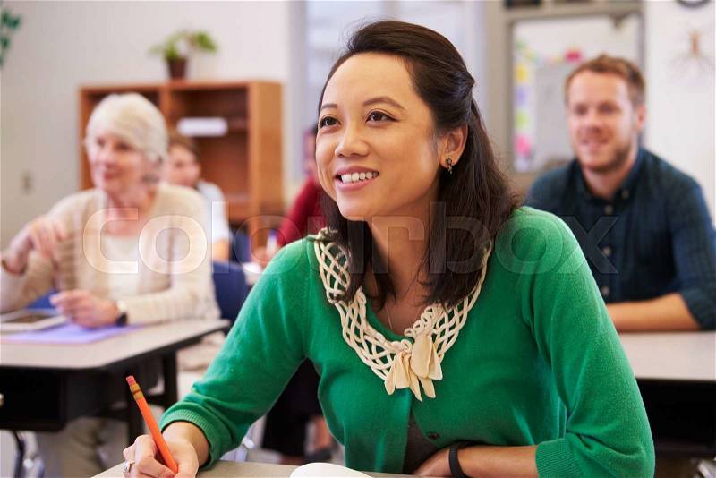Asian woman looking at the board in an adult education class, stock photo