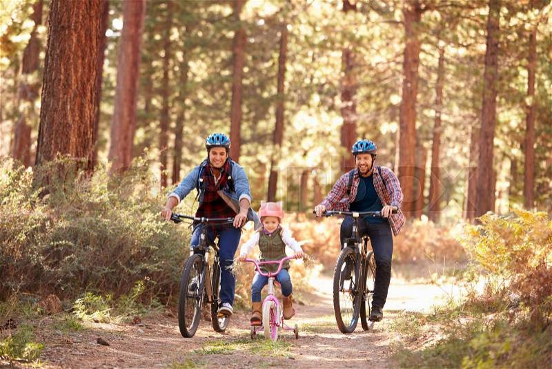 Gay Male Couple With Daughter Cycling Through Fall Woodland, stock photo