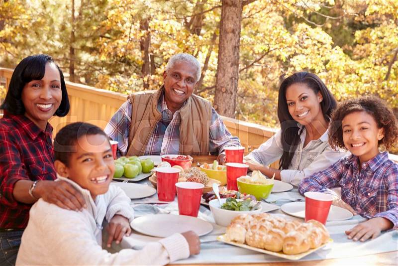 Grandparents With Children Enjoying Outdoor Meal, stock photo
