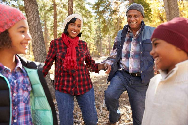 Grandparents With Children Walking Through Fall Woodland, stock photo