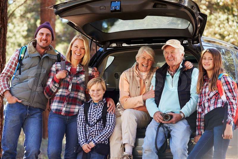 Multi generation family standing by a car before forest hike, stock photo