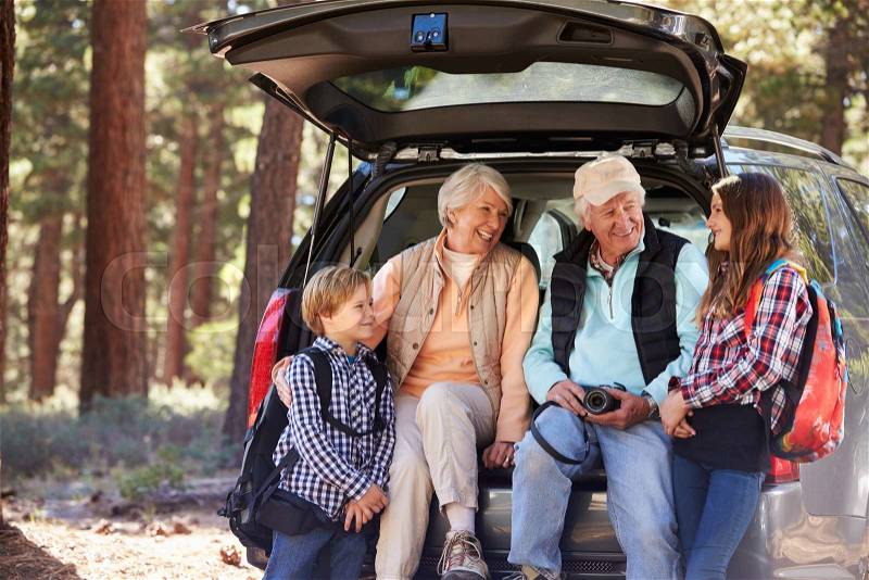 Grandparents and grandkids at the back of car before hiking, stock photo
