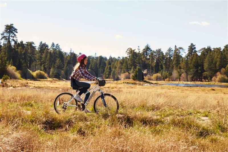 Girl cycling in the countryside, California, USA, stock photo
