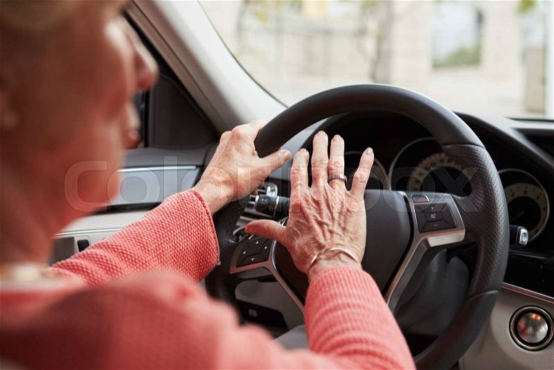 In car view of senior female driver using the horn in a car, stock photo
