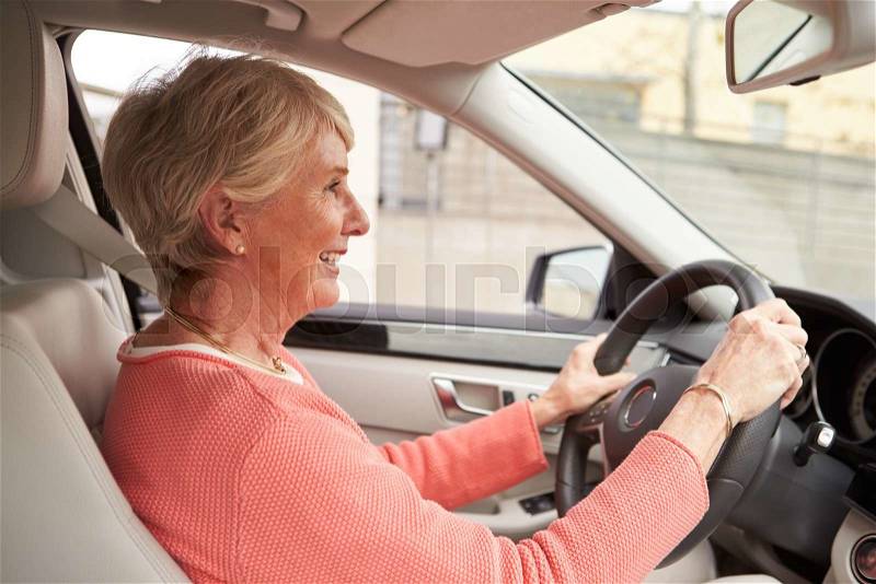 In car view of senior female driver at the wheel of a car, stock photo