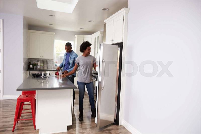 Young Couple Relaxing In Apartment Kitchen Together, stock photo