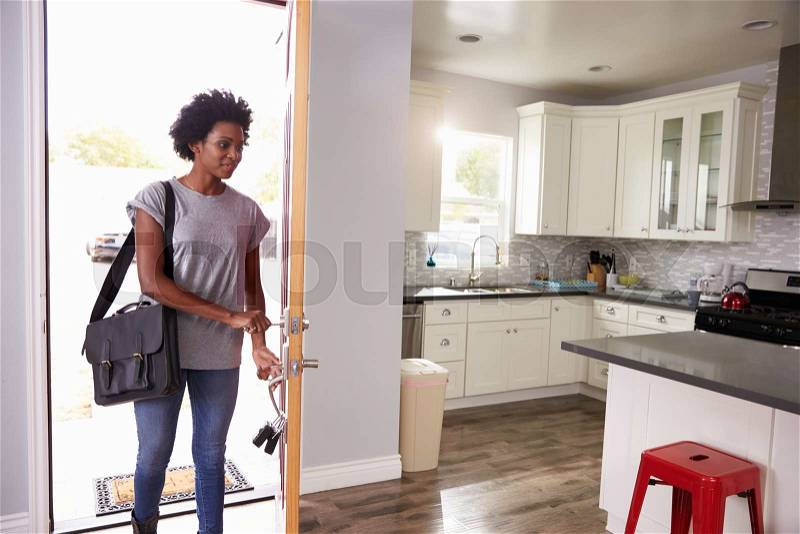 Woman Coming Home From Work And Opening Door Of Apartment, stock photo