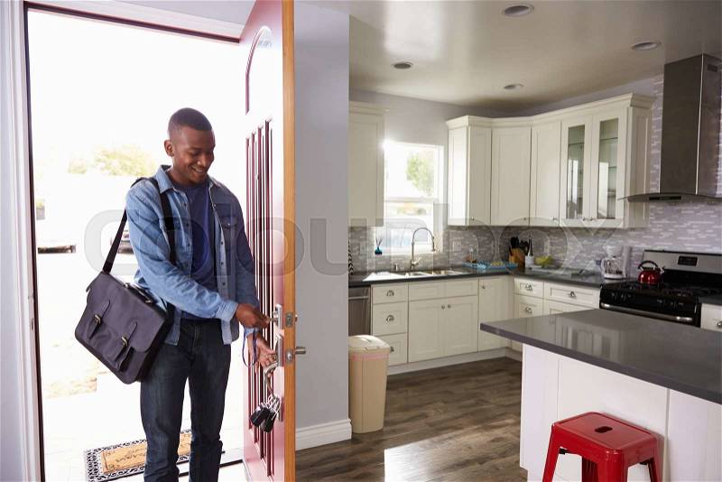 Man Coming Home From Work And Opening Door Of Apartment, stock photo