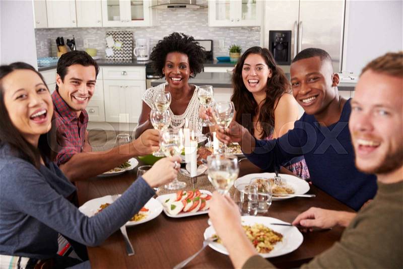Group Of Friends Making A Toast At Dinner Party, stock photo