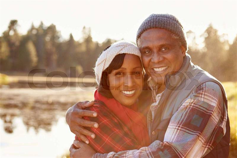 Portrait Of Senior African American Couple Walking By Lake, stock photo