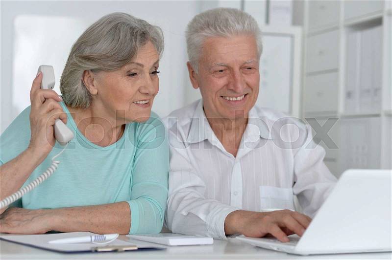 Portrait of a senior couple working with laptop, stock photo
