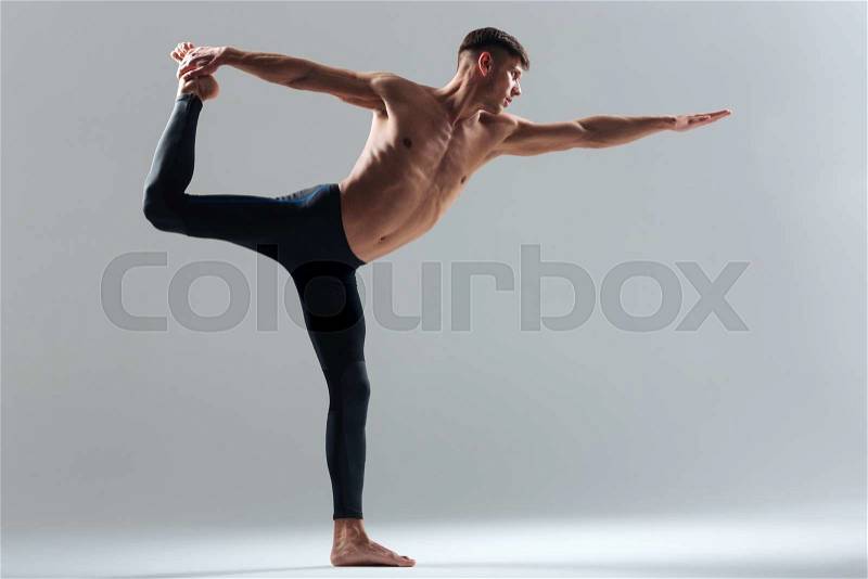 Handsome man doing balance pose isolated on a white background, stock photo