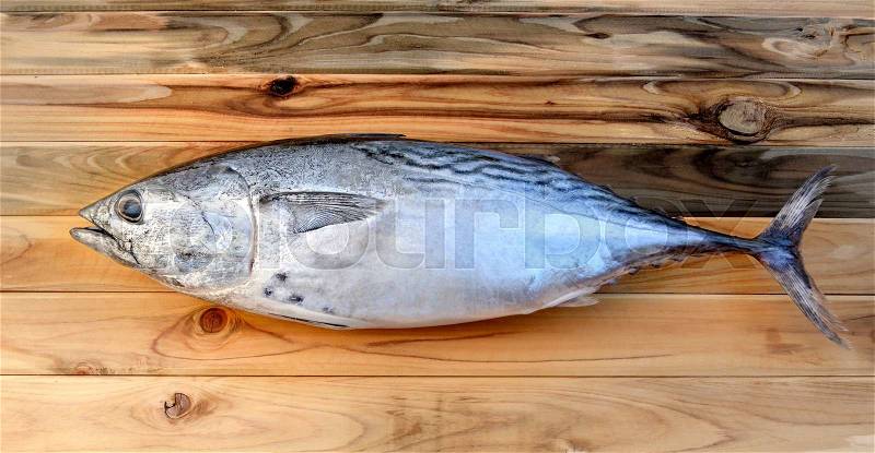 Fresh eastern little tuna from fishery market with wooden photo in sunlight time, stock photo