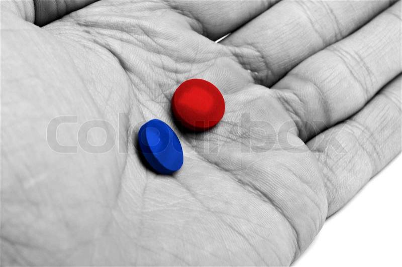 Hand with blue and red pills isolated on a white background, stock photo