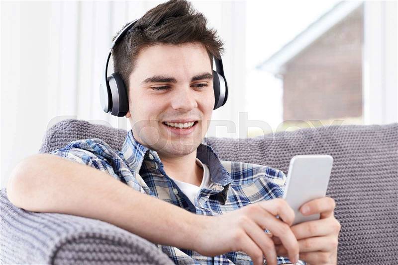 Man Streams Music From Mobile Phone To Wireless Headphones, stock photo